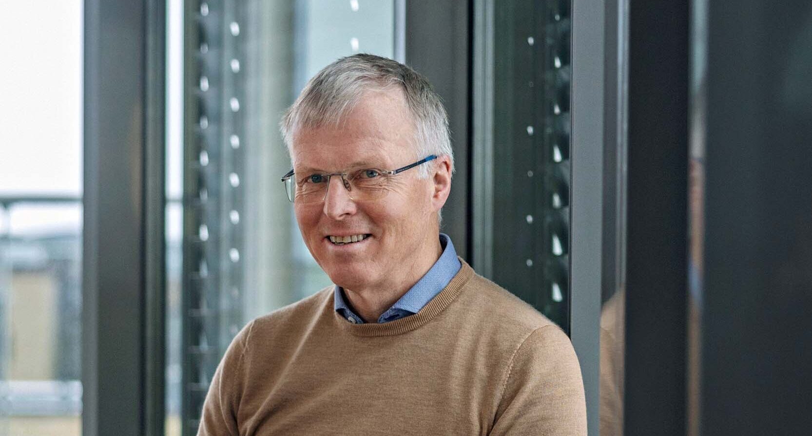 Bildet viser Morten Sollerud, adm.dir i Norilia. Han har på seg lysebrun genser og sitter i en stol mens han ser inn i kamera. Det er et portrettbilde.